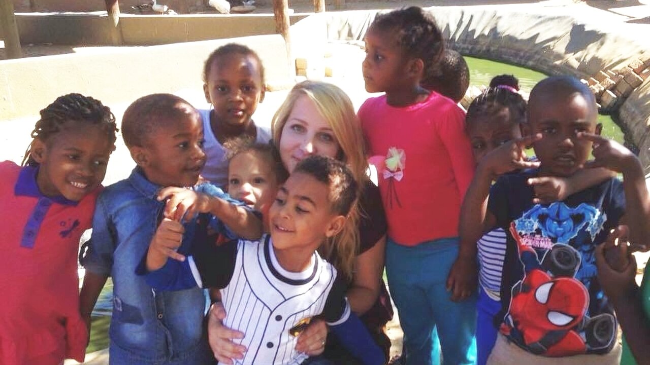 Sophia ist umringt von Kindern in Namibia.
