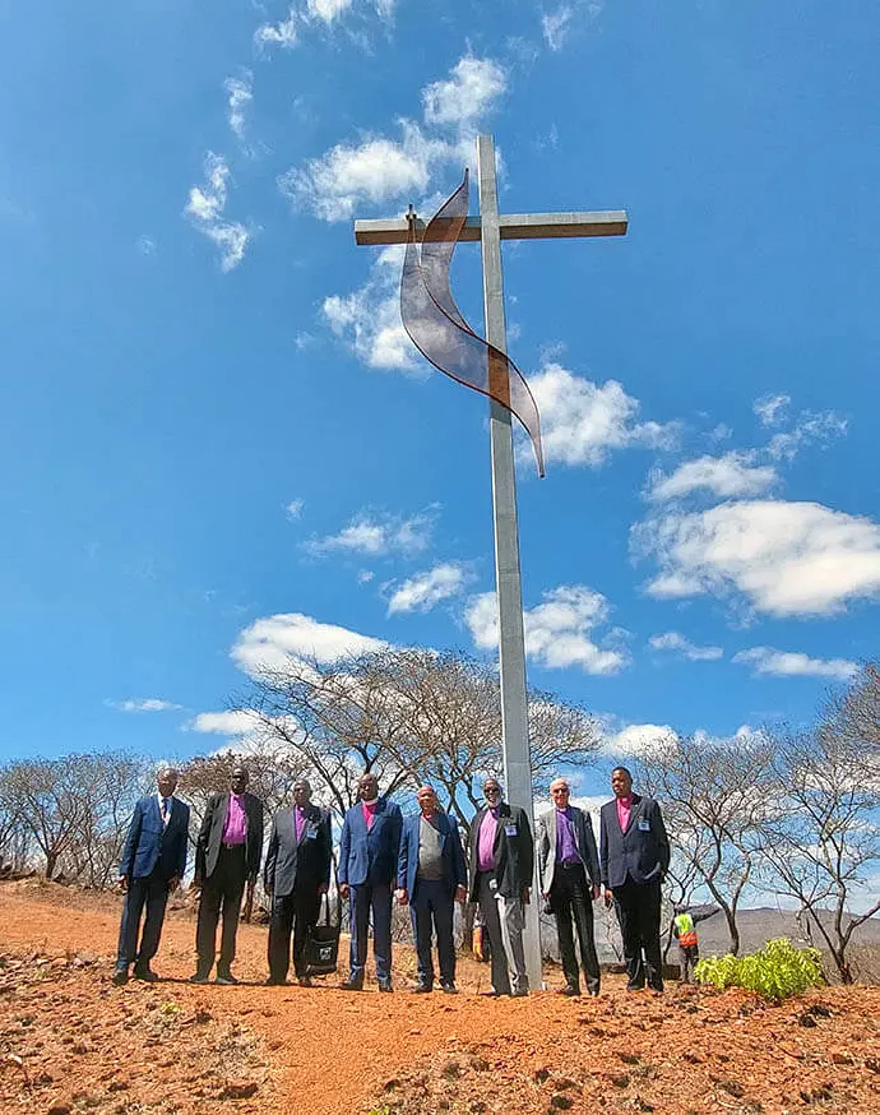 Afrikanische Bischöfe stehen vor einem Berg vor einem Kreuz